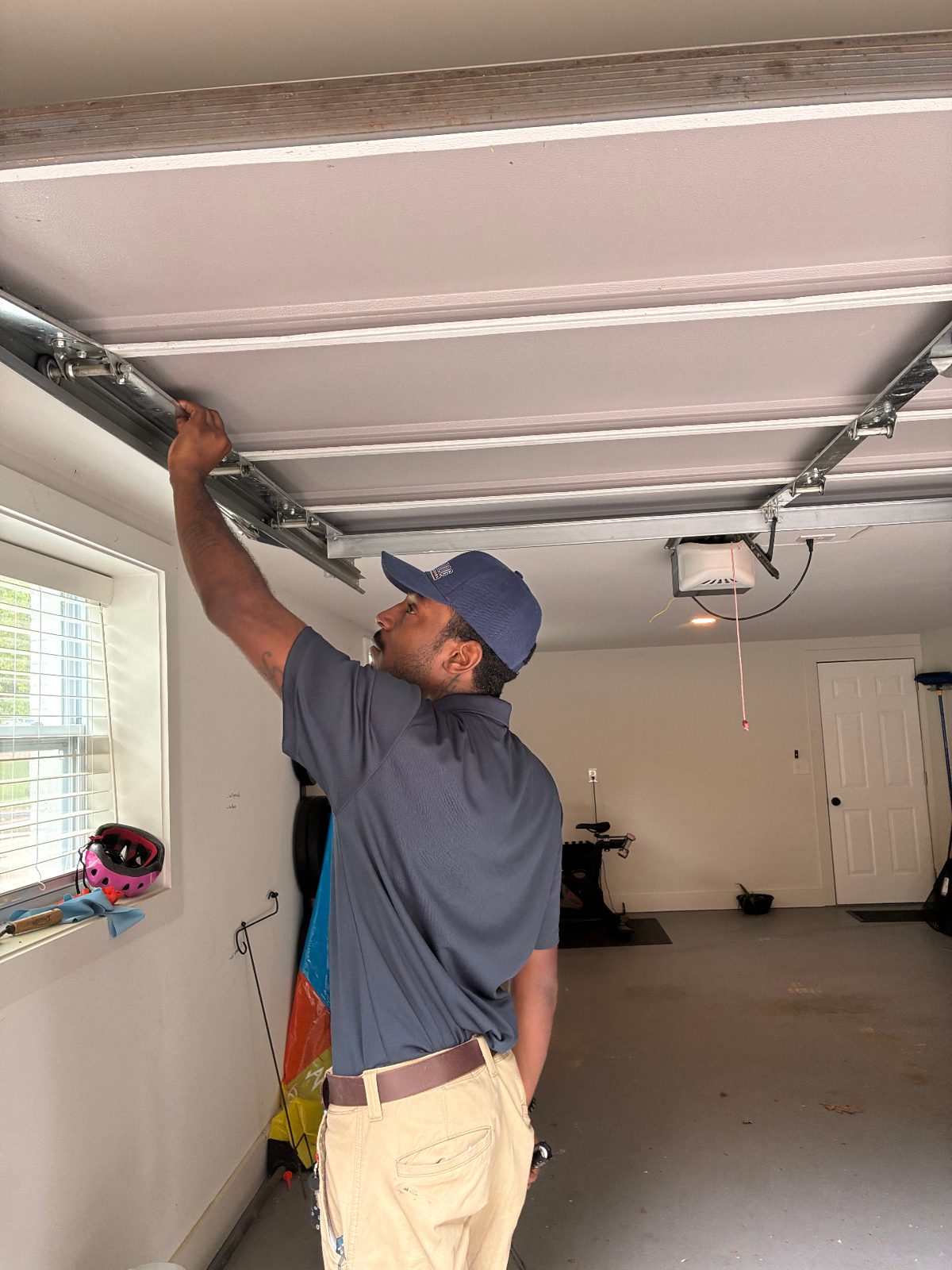 Top Dog Garage Doors technician inspecting a garage door torsion spring in Atlanta, GA