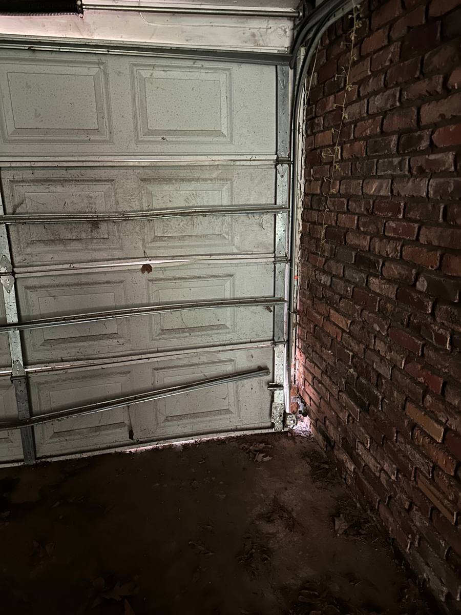 Interior view of the garage door sections, hinges, and rollers on the existing door system in Decatur GA