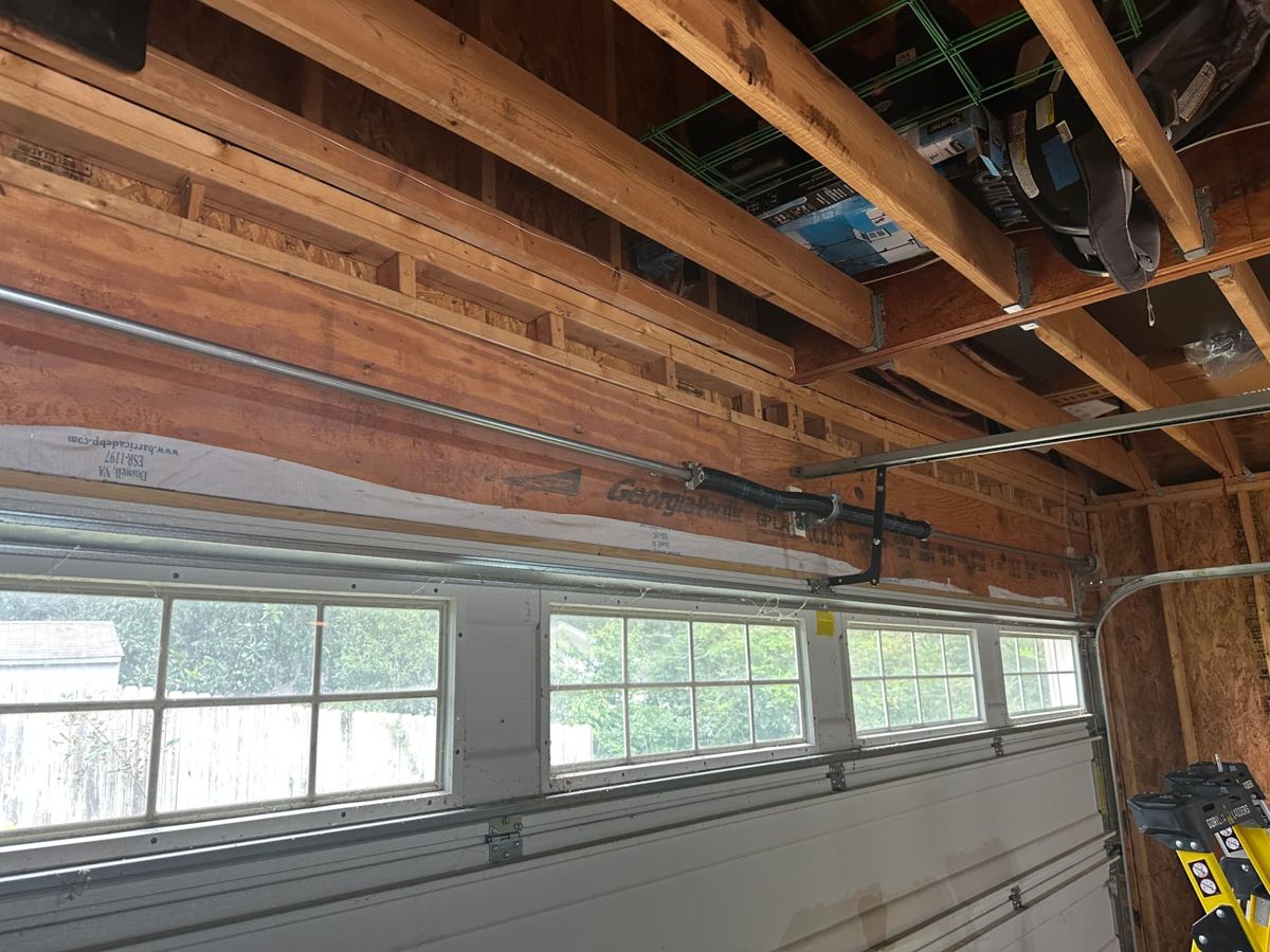 New torsion tube and dual spring assembly mounted above the garage door opening after conversion in Atlanta
