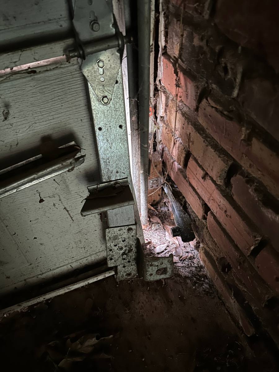Detail of the garage door jamb, hinge, and track hardware retained after the panel replacement in Decatur GA